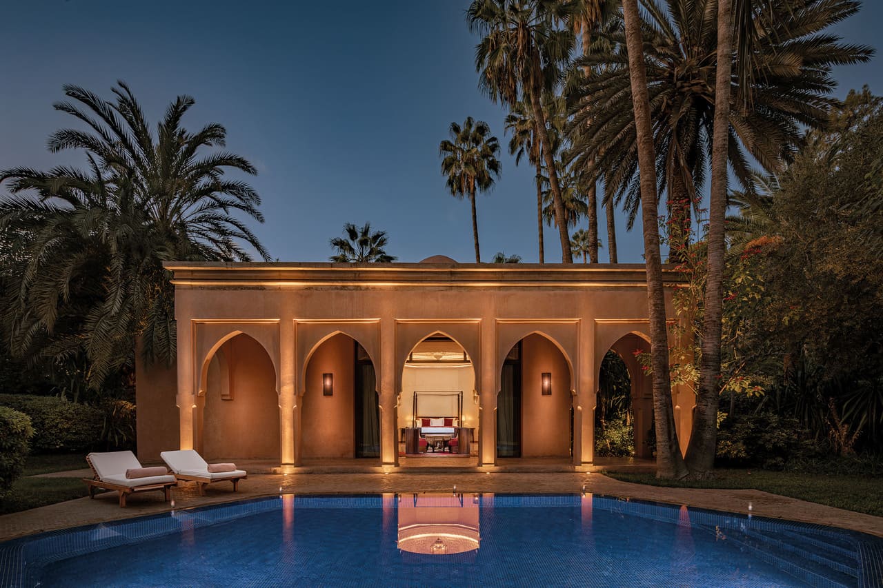 Private villa with pool and arched architecture at dusk at Es Saadi Marrakech Resort